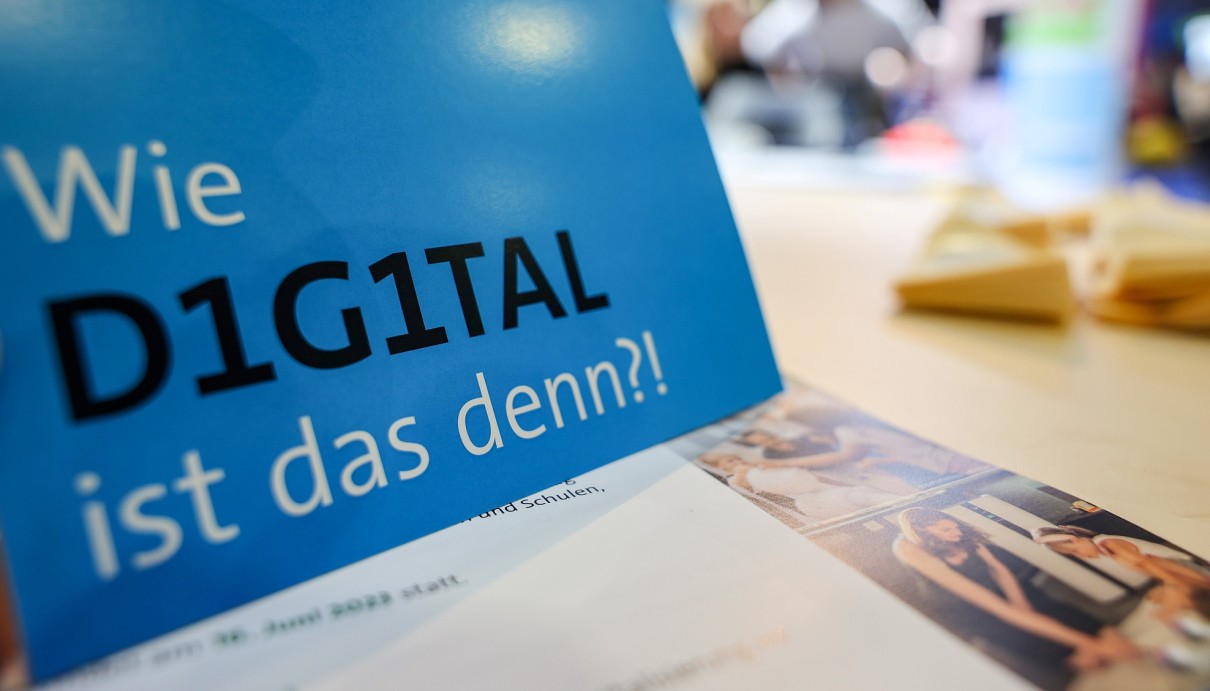 Ein blaues Schild mit der Aufschrift 'Wie digital ist das denn?'