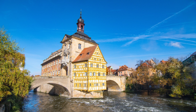 Ein Gebäude mit Brücke an einem Fluss.