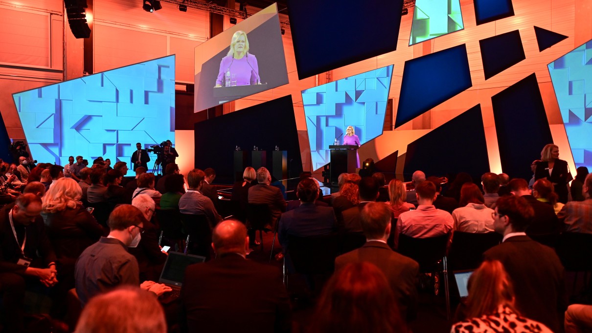 Bundesinnenministerin Nacy Faeser zur Eröffnung der Smart Country Convention auf der Bühne. Im Vordergrund sitzt das Publikum. 