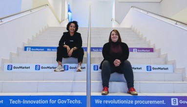 Zwei junge Frauen, Melanie und Jana, sitzen auf der Treppe zum GovMarket Büro.