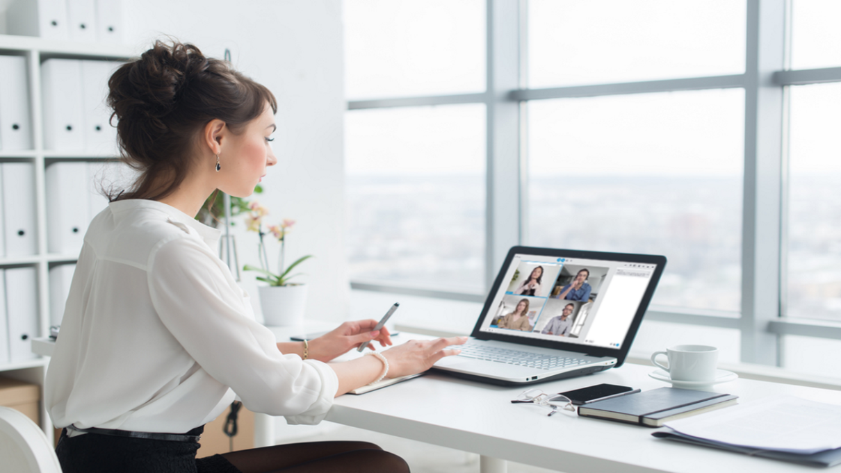 Woman at a laptop talking to other people