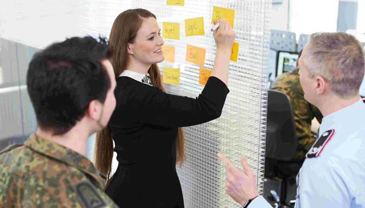Szene mit drei Personen beim brainstorming an einem Board Szene mit drei Personen beim brainstorming an einem Board